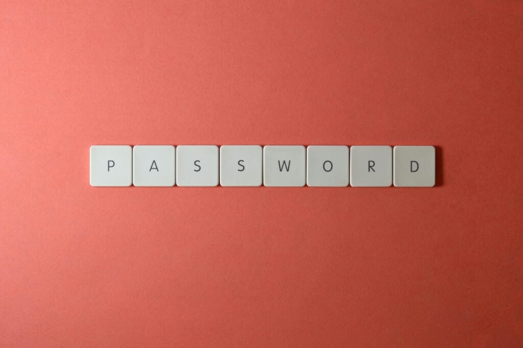 Focus on password security with white keyboard tiles spelling 'PASSWORD' on a coral background.